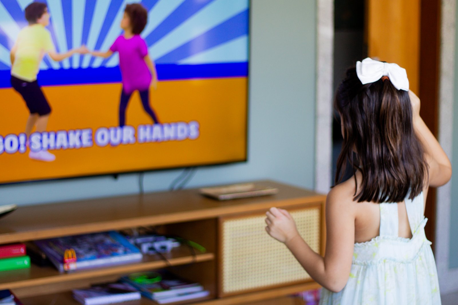 Criança dançando em frente à televisão durante uma atividade musical