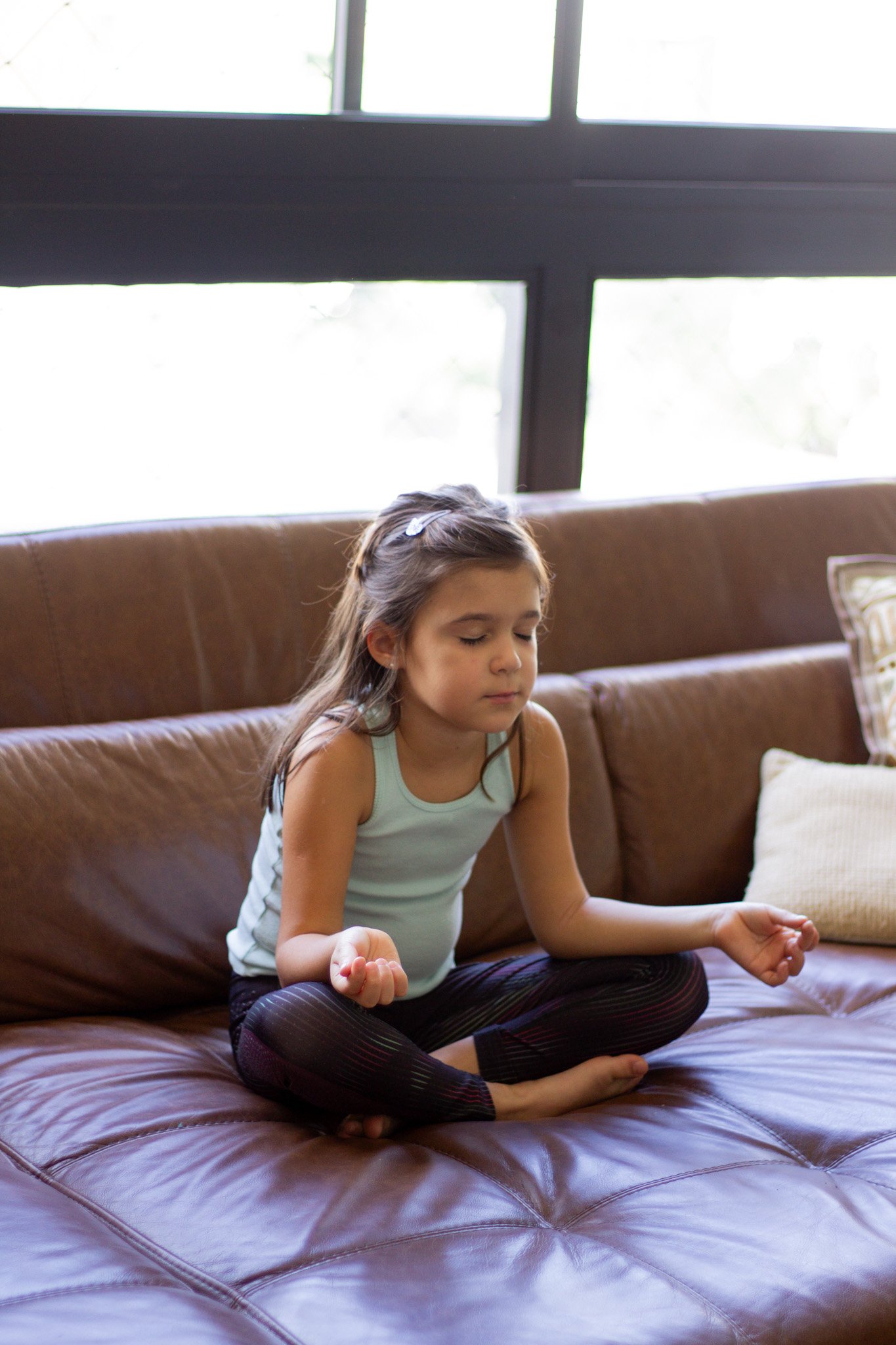 Criança fazendo yoga guiada por um conteúdo infantil em inglês